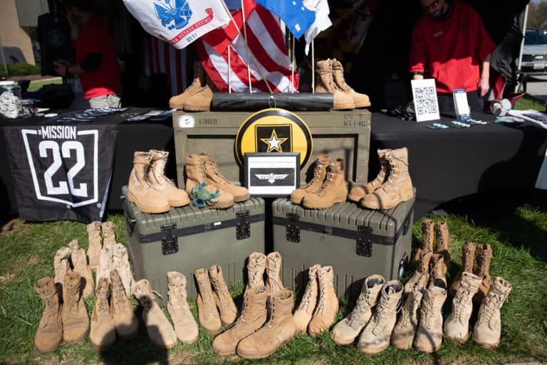 Military boots and patriotic display featured at the Mission 22 veteran awareness event.